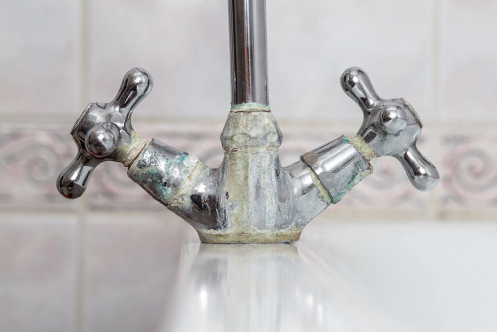 crusty white mineral scale buildup on a Denver kitchen faucet from hard water